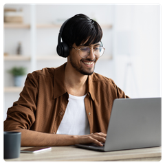 Someone wearing headphones while engaging in an online session on a laptop
